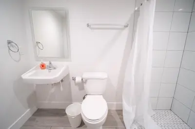 a white bathroom with a toilet and a sink at Stylish Private Ensuite Room near USC in Los Angeles