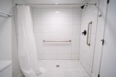 a bathroom with a shower with a tiled floor at Stylish Private Ensuite Room near USC in Los Angeles