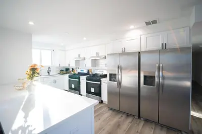 a kitchen with stainless steel appliances and white cabinets at Modern Private Ensuite Room near USC in Los Angeles
