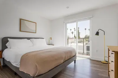 a white bedroom with a bed and a large window at Blueground Sawtelle rooftop nr Culver City Park LAX-1373 in Los Angeles
