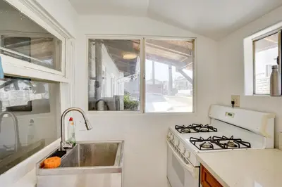 a white kitchen with a stove and a sink at 3 Mi to Beaches Low-Key San Pedro Rental! in San Pedro