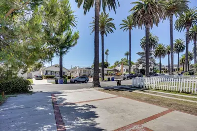 a street with palm trees and a white fence at 3 Mi to Beaches Low-Key San Pedro Rental! in San Pedro