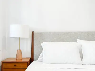 a bed with white sheets and a lamp on a night stand at Cozy Boho 2BR Near Beverly Hills - DOH2 - CUL in Los Angeles