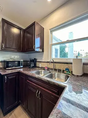 a kitchen with wooden cabinets and a sink and a window at Cozy Boho 2BR Near Beverly Hills - DOH2 - CUL in Los Angeles