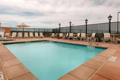 a large swimming pool with chairs and tables at Wyndham Garden Lancaster CA in Lancaster