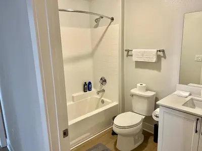 a bathroom with a toilet and a tub and a sink at Miracle Mile Apartments in Los Angeles