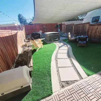 a backyard with a grill and green grass at Star Gazer's Paradise in Apple Valley