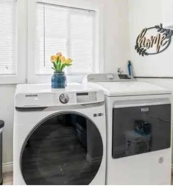 a washing machine in a kitchen with a vase of flowers at Prime location King Bed! Private house1 in Alhambra