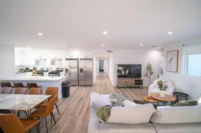 a living room with a couch and a table and a kitchen at The Command Suite Urban Comfort Near USC in Los Angeles