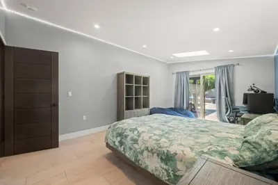 a bedroom with a bed and a desk and a television at The Royer Retreat With Pool and Hot tub in Los Angeles