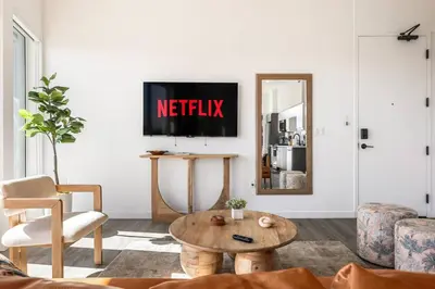 a living room with a tv with the netflix sign on the wall at Skyline Haven Near Dodger Stadium with Views in Los Angeles