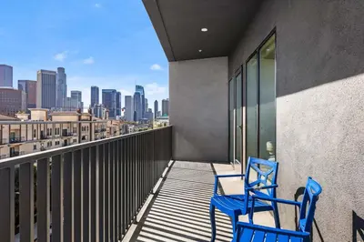 two blue chairs on a balcony with a view of the city at Skyline Haven Near Dodger Stadium with Views in Los Angeles