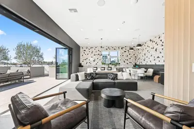 a living room with leather furniture and a large window at Chic Studio, Walk to Downtown With Skyline Views in Los Angeles