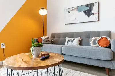 a living room with a couch and a table at Chic Studio, Walk to Downtown With Skyline Views in Los Angeles