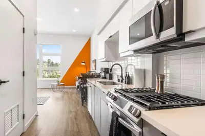 a kitchen with white counters and a stove top oven at Chic Studio, Walk to Downtown With Skyline Views in Los Angeles