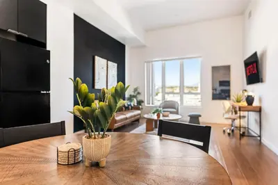 a dining room and living room with a wooden table at Central LA Hideaway, Steps from Japanese Village in Los Angeles