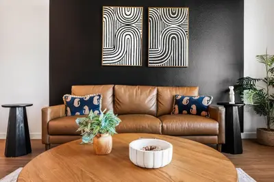 a living room with a brown couch and a table at Central LA Hideaway, Steps from Japanese Village in Los Angeles