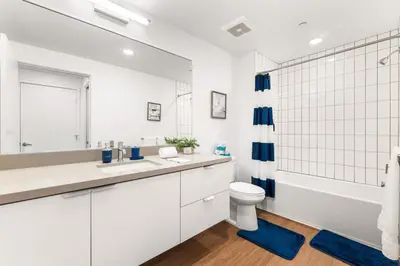 a white bathroom with a tub and a toilet and a sink at 2BD 2BA Stylish Arts District Retreat, Walk to Little Tokyo in Los Angeles