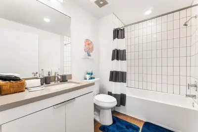 a white bathroom with a toilet and a shower at 2BD 2BA Stylish Arts District Retreat, Walk to Little Tokyo in Los Angeles