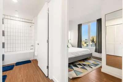 a white bedroom with a bed and a window at 2BD 2BA Stylish Arts District Retreat, Walk to Little Tokyo in Los Angeles
