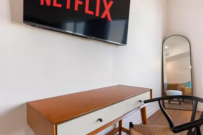 a tv hanging on a wall above a dresser at Modern Studio Retreat in the Heart of Art District in Los Angeles