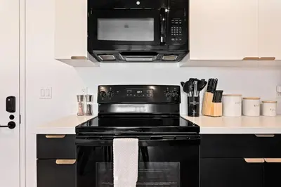 a kitchen with a black stove and a microwave at Arts District Condo, Walk to Little Tokyo Plaza in Los Angeles