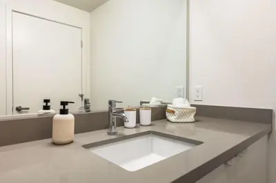 a bathroom with a sink and a large mirror at Stylish 2BD Haven with Scenic DTLA Views and Parking in Los Angeles