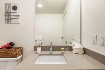 a white bathroom with a sink and a mirror at Stylish 2BD Haven with Scenic DTLA Views and Parking in Los Angeles