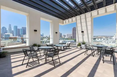 a patio with tables and chairs and large windows at Stylish 2BD Haven with Scenic DTLA Views and Parking in Los Angeles