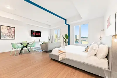 a bedroom with a bed and a dining room at Chic Studio with Stunning DTLA Views, Walk to Metro in Los Angeles