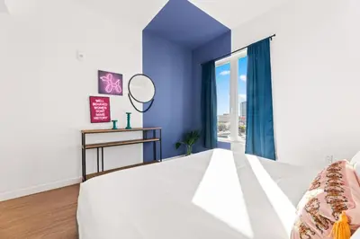 a bedroom with a large bed and a mirror at Spacious 1-BD with Stunning City Views in DTLA in Los Angeles