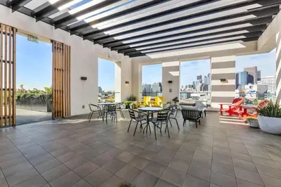 a large patio with tables and chairs and windows at Spacious 1-BD with Stunning City Views in DTLA in Los Angeles