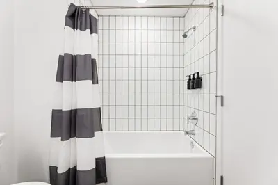 a shower with a black and white shower curtain in a bathroom at Spacious 1-BD with Stunning City Views in DTLA in Los Angeles