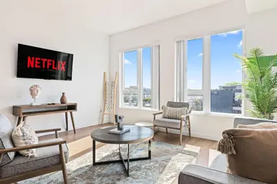 a living room with white walls and windows at Unique 1-Bedroom DTLA Escape with City Views in Los Angeles