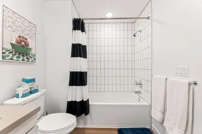 a white bathroom with a toilet and a shower at Unique 1-Bedroom DTLA Escape with City Views in Los Angeles