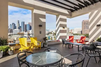 a patio with tables and chairs and a view of the city at Unique 1-Bedroom DTLA Escape with City Views in Los Angeles
