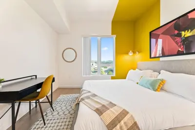 a bedroom with a bed and a desk and a window at Designer Stay in Arts District, Walk to Little Tokyo in Los Angeles