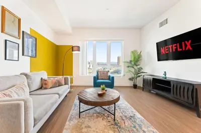 a living room with a couch and a tv at Designer Stay in Arts District, Walk to Little Tokyo in Los Angeles