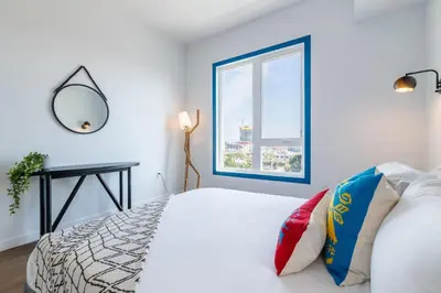 a white bedroom with a bed and a window at Chic and Cozy Home, Walk to Little Tokyo with Parking in Los Angeles