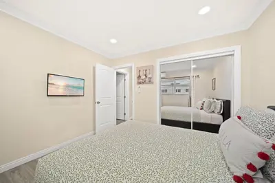 a white bedroom with a bed and a mirror at Vibrant & Refreshing - 12 min to Downtown LA in Alhambra