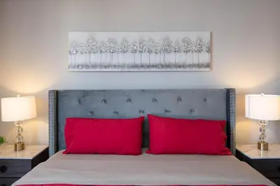 a bed with two red pillows in a bedroom at Modern Hollywood Apt Rooftop Pool & Skyline Views in Los Angeles