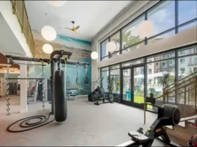 a gym with cardio equipment in a large room with windows at Cozy 2bd Apt Near Disneyland Anaheim Conv Center in Anaheim