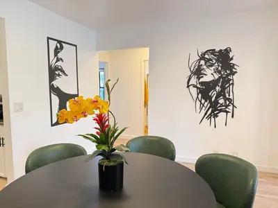 a table and chairs with a vase with yellow flowers at Modern Duplex with 6 beds and Sofa bed in Miracle Mile Longwood in Los Angeles
