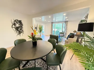 a living room with a table and green chairs at Modern Duplex with 6 beds and Sofa bed in Miracle Mile Longwood in Los Angeles
