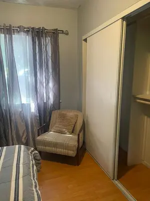 a bedroom with a bed and a chair and a window at BACK HOUSE in PASADENA in Pasadena