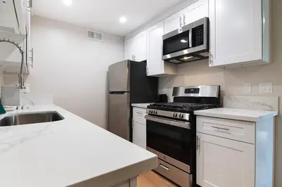 a kitchen with white cabinets and a black stove top oven at Stylish 1BR Near Universal Studios with Parking in Los Angeles
