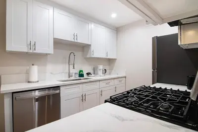 a kitchen with white cabinets and a stove top oven at Stylish 1BR Near Universal Studios with Parking in Los Angeles