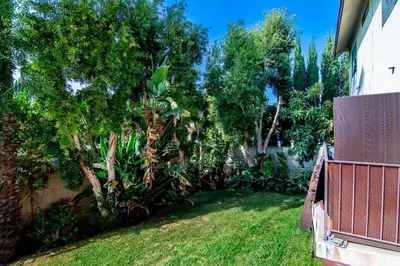 a yard with a fence and trees and grass at Stylish 1BR Near Universal Studios with Parking in Los Angeles