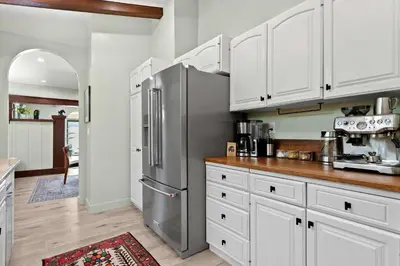 a kitchen with white cabinets and a stainless steel refrigerator at New Listing Marina Villa by Colby & Conrad in Los Angeles