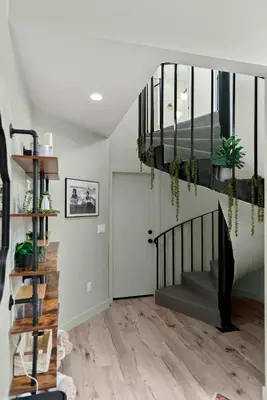 a living room with a staircase with potted plants at New Listing Marina Villa by Colby & Conrad in Los Angeles